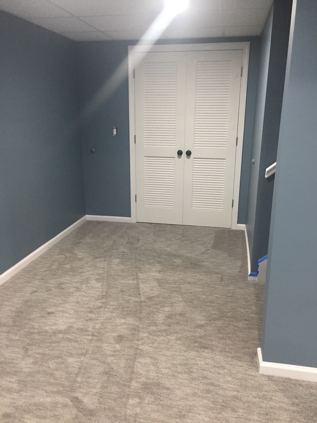 Finished basement room with louvered closet doors and new trim